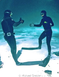 Apnea divers greet each other under the ice at Morrison's... by Michael Grebler 